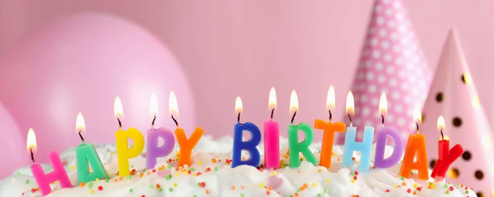 Birthday,Cake,With,Burning,Candles,On,Pink,Background,,Closeup